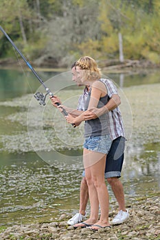man teaching woman how to fish