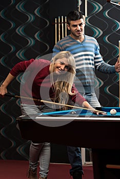 Man Teaching Woman How To Play Pool