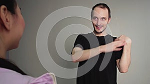 Man teaching young woman hip hop movement at dancing class. Young dancing people in studio during exercise dancer