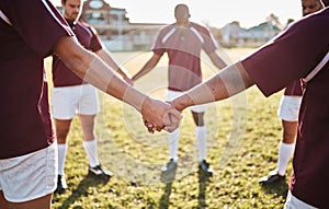 Man, team and holding hands for sports huddle, collaboration or coordination on grass field. Group of men touching hand