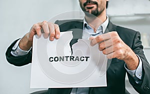 A man tearing paper to present about breaking contract or agreement concept