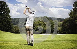 Man teeing-off golf ball.