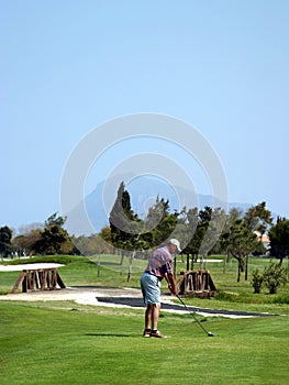 Man teeing off on golf course in sunny Spain