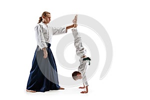 Man and teen boy fighting at aikido training in martial arts school