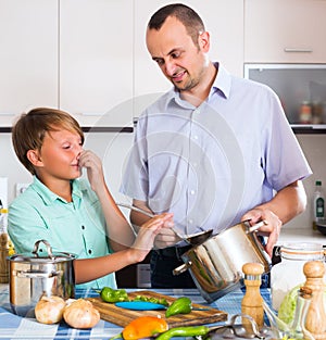 Man and teenager cooking together