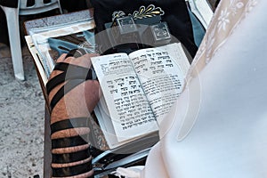 Man with tefillin and torah at Western Wall in Jerusalem.