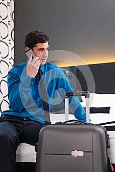 Man telephoning at arrival in hotel room