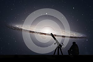 Man with telescope looking at the stars. Sombrero Galaxy M104