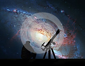 Man with telescope looking at the stars. Spiral Galaxy M106
