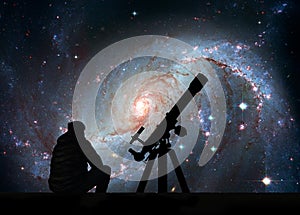 Man with telescope looking at the stars. Stellar Nursery NGC 1672. Spiral galaxy in the constellation Dorado.Elements of this