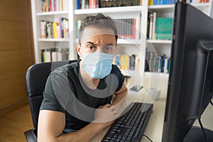 Man teleworking at home with mask