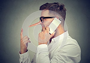 Man telling lies while having phone call photo