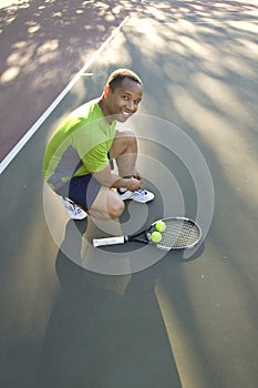 Man on Tennis Court Tying His Shoe