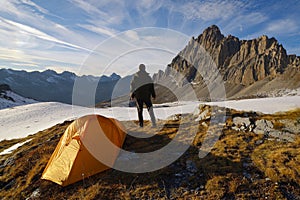 Man with tent observes the Alps