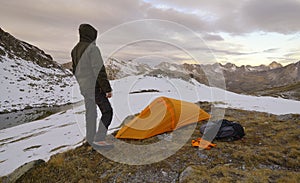 Man with tent observes the Alps