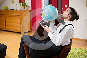 Man with terrestrial globe in his living room