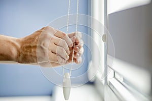 Man testing cassette roller blinds on windows