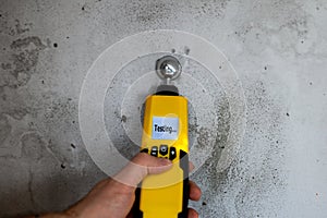 Man testing the humidity in a wall with a moisture meter.