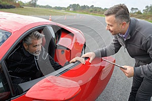 man testing red car photo