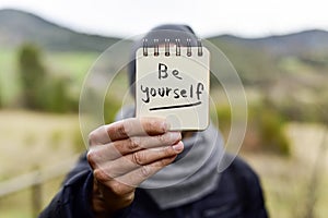 Man and text be yourself in a note