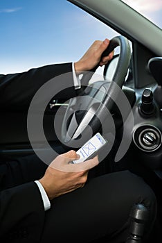 Man texting while driving his car