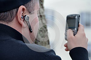 Man Texting & Wearing Wireless Earpiece