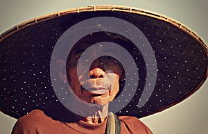 A man in Thailand wears a large bamboo hat