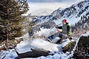 Man with thermos of tea in the mountains