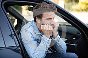 man thinking beside car
