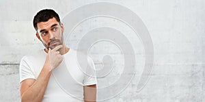 Man thinking over gray wall background