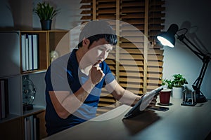 man thinking while using tablet at night