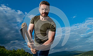 man threaten with axe. aggressive man hold ax. brutal man on sky background