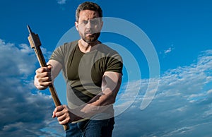 man threaten with axe. serious man hold ax. brutal man on sky background