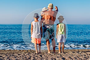 Man and three children looking at the sea