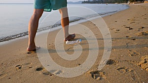 Man throw out plastic bottle garbage on sand beach