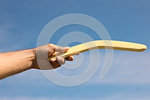 Man throwing boomerang against blue sky, closeup