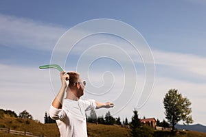 Man throwing boomerang outdoors on sunny day. Space for text