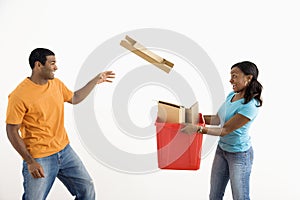 Man throwing cardboard into bin.