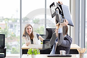 Man throwing computer screen at female co-worker