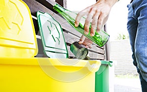 Man throwing the glass bottle andtin can into differennt dustbins