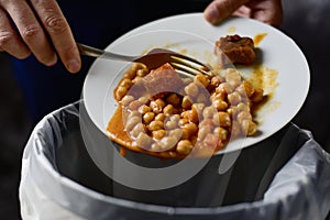 Man throwing leftovers to the trash bin