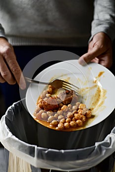 Man throwing leftovers to the trash bin