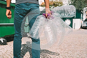 Man throwing out empty used big plastic water bottles. Bottled water pollution