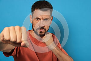 Man throwing punch on light blue background. Space for text