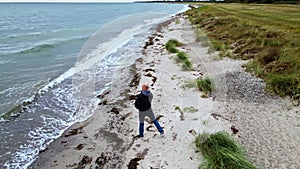 Man throwing rocks into the sea