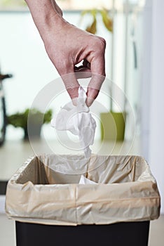 Man throwing a used wet wipe to the trash bin