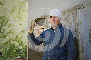 A man throws a cement mortar on a brick wall