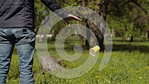 A man throws out a used plastic cup on nature