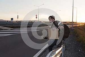 Man thumbing on a road Empty cardboard