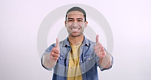 Man, thumbs up and promotion in studio, face and approval emoji by pink background. Asian male person, portrait or yes